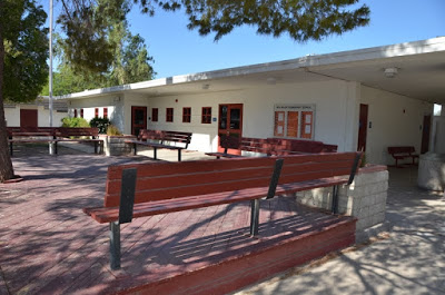 A bench in front of a school building